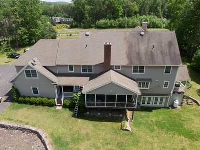 Aerial view of roof cleaning in Camano Island WA in progress with one side clean and the other still dirty