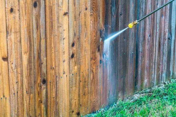 Fence cleaning in Marysville WA, showing one side dirty and the other side freshly pressure washed