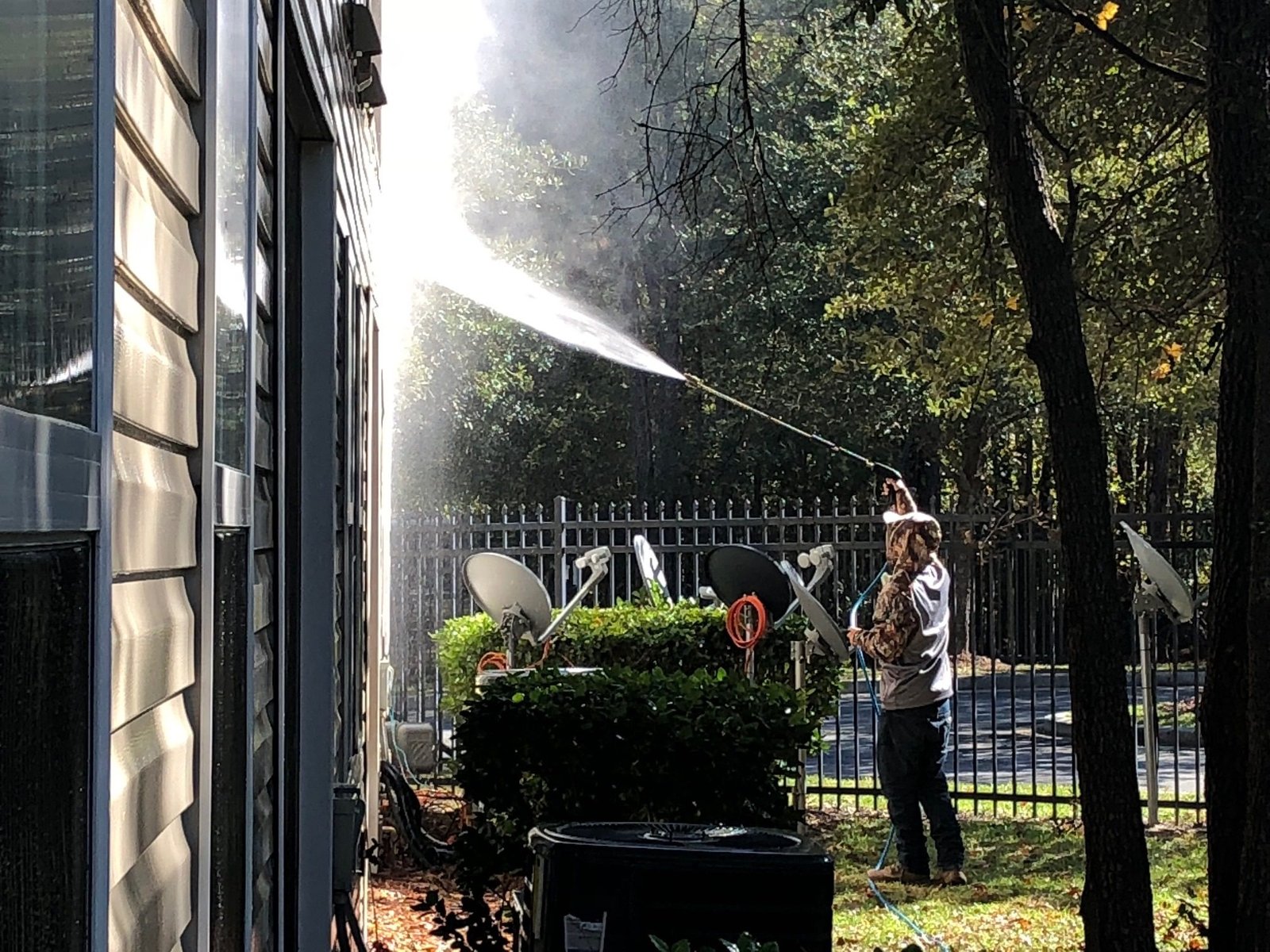 Technician performing house washing on a residential home in Lake Stevens WA