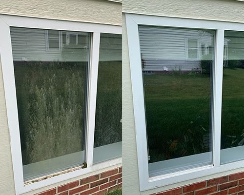Before and after results of a residential window cleaned in Camano Island WA on a beige house with brick showing visible improvement