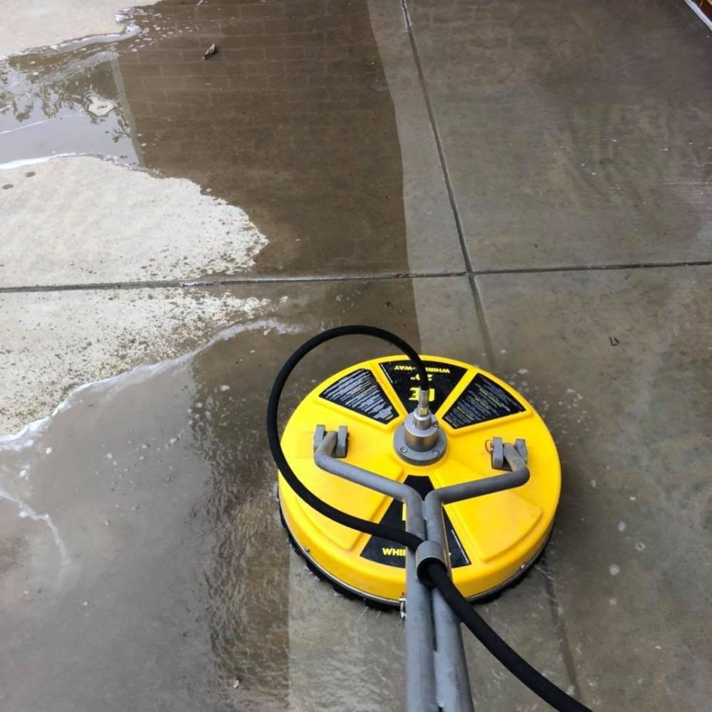 Before and after results of a driveway cleaned with pressure washing in Arlington WA using a surface cleaner