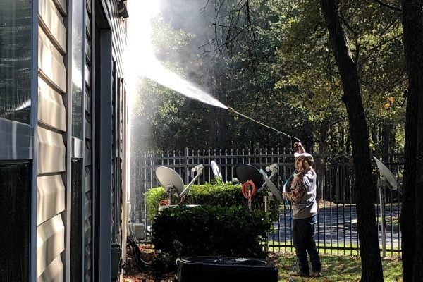 Technician performing house washing on a residential home in Marysville WA